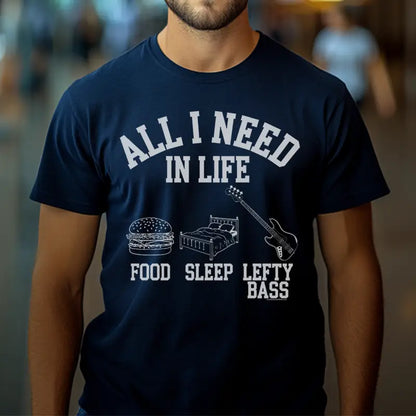 Navy unisex t-shirt featuring the white text "All I Need in Life" with icons for food, sleep, and a left-handed bass guitar.