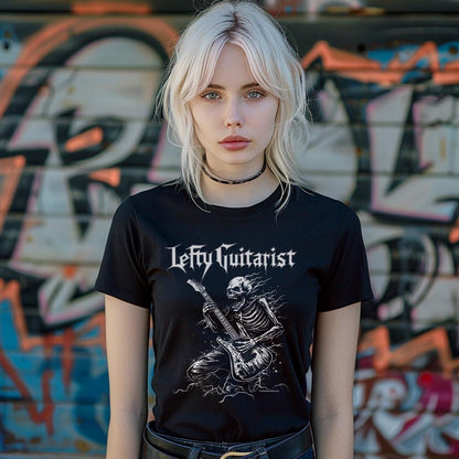 Black unisex T-shirt featuring a skeleton playing guitar with "LeftyGuitarist" text, worn by a model against a graffiti background
