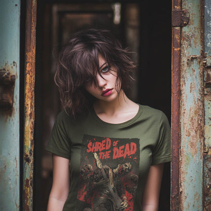 Woman wearing a unisex green T-shirt featuring a zombie guitarist graphic with the text "Shred of the Dead" in red and black.