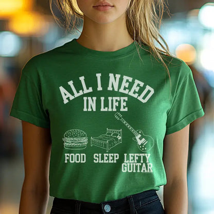 Green unisex T-shirt featuring the text "All I Need in Life - Food, Sleep, Lefty Guitar" with icons of a burger, bed, and a lefty guitar