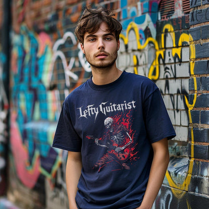 Flaming red skeleton graphic on a navy unisex T-shirt, worn by a man against a graffiti-covered wall.
