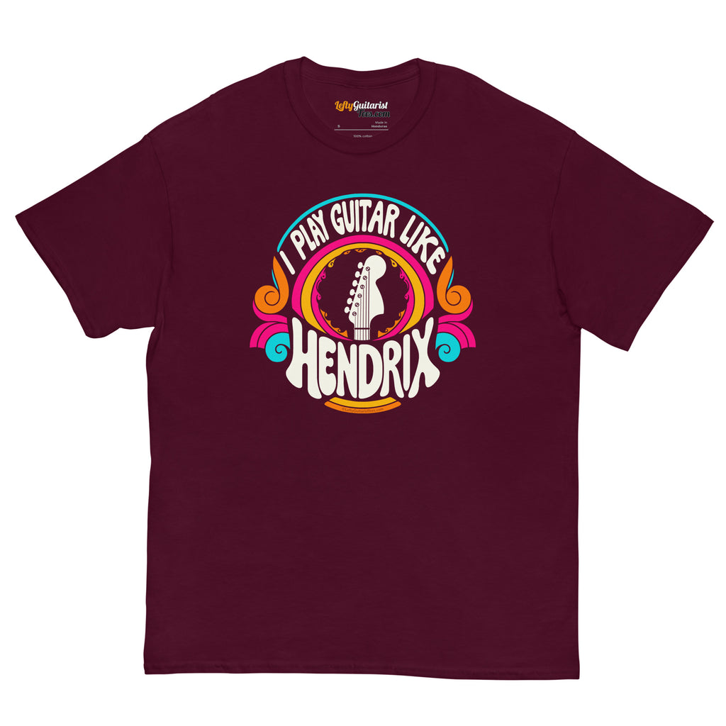 Maroon unisex t-shirt featuring a colorful graphic that reads "I play guitar like HENDRIX" with a guitar headstock illustration.