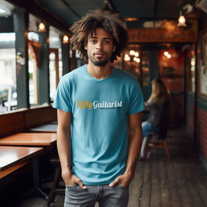 Unisex blue LeftyGuitarist T-shirt worn by a man with curly hair, displayed in a rustic café setting.