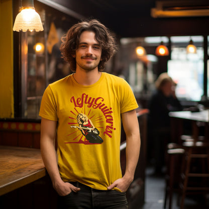 Lefty blonde guitarist unisex t-shirt in yellow, featuring a graphic of a guitarist with a left handed guitar, worn by a smiling male