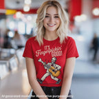 Blonde American woman wearing a red unisex T-shirt featuring a white-haired man in a white suite playing a left handed guitar made out of a chicken drumstick, featuring the text "It's Fingerpickin' Good!".