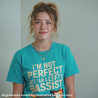 Unisex blue t-shirt featuring the text "I'm not perfect but I am a lefty bassist" with a lefty bass guitar graphic.