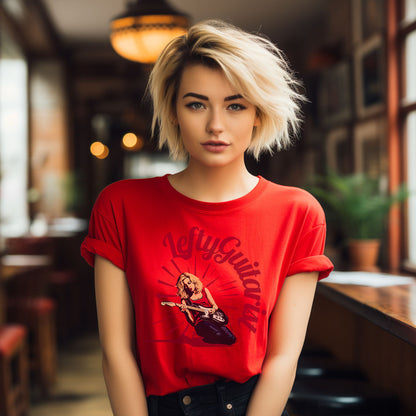 Red unisex T-shirt featuring a blonde left handed guitarist graphic, worn by a model with short hair in a cafe setting.