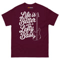 Maroon unisex t-shirt featuring the text "Life is Better with a Lefty Bass" and a lefty bass guitar graphic.