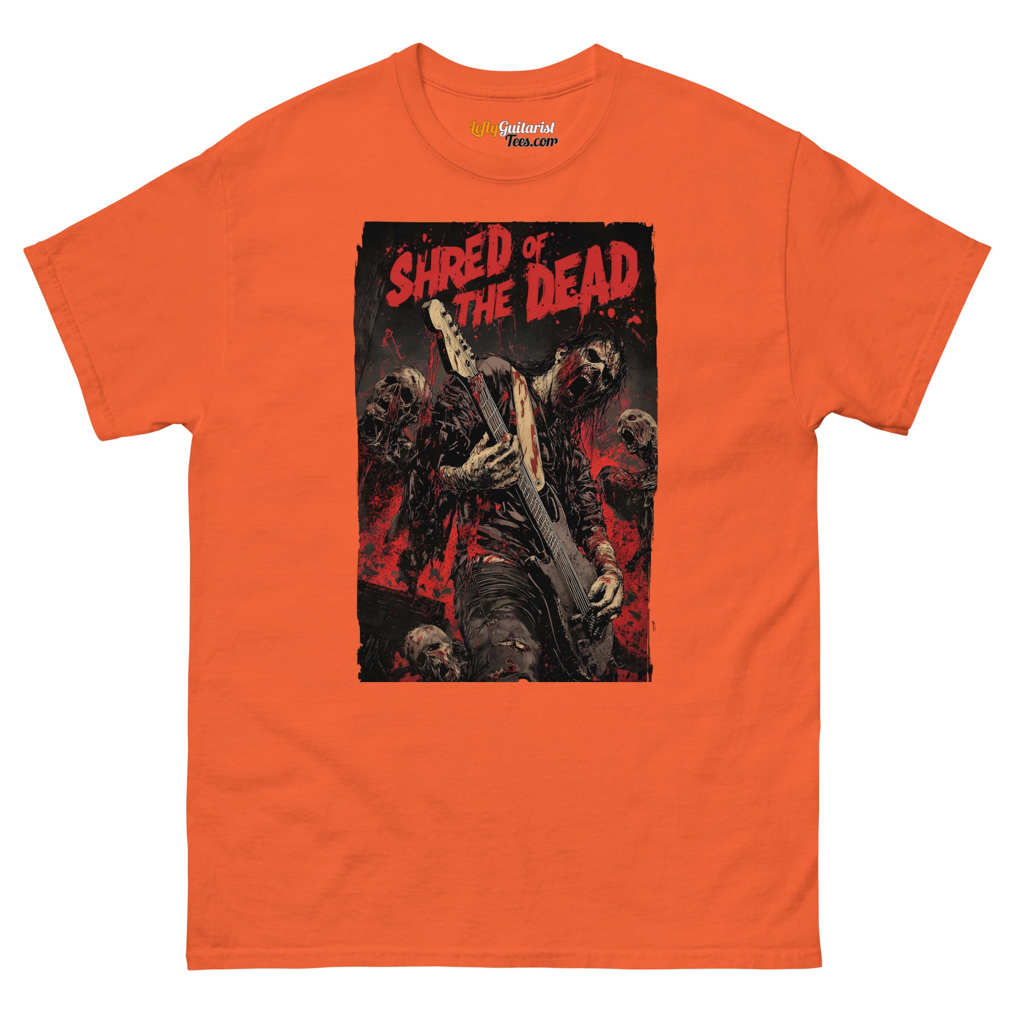 Orange unisex T-shirt featuring a zombie guitarist graphic with the text "Shred of the Dead" and skulls in the background.