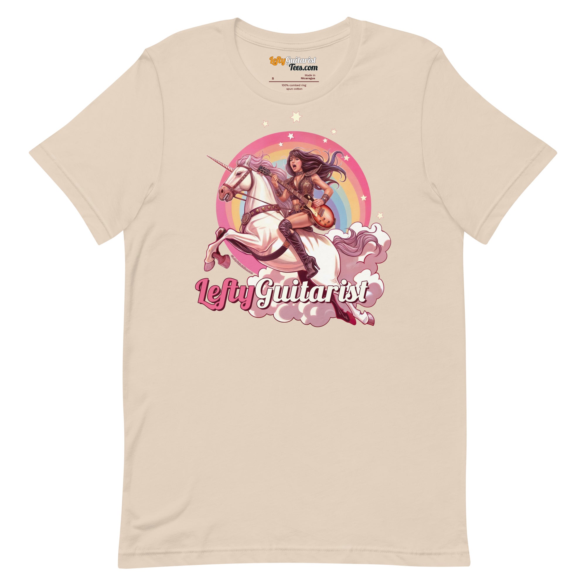 Cream unisex t-shirt featuring a unicorn warrior graphic with the text "Lefty Guitarist" in pink and rainbow background.